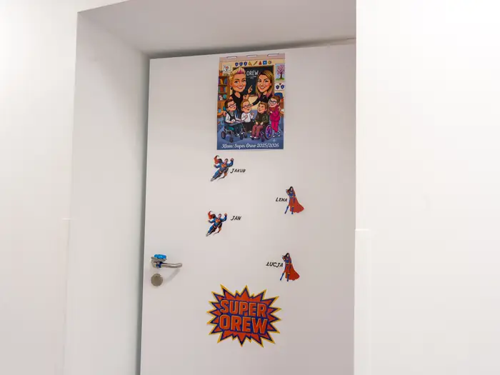 Drzwi klasy Super Orew z komiksową tabliczką i imionami uczniów.