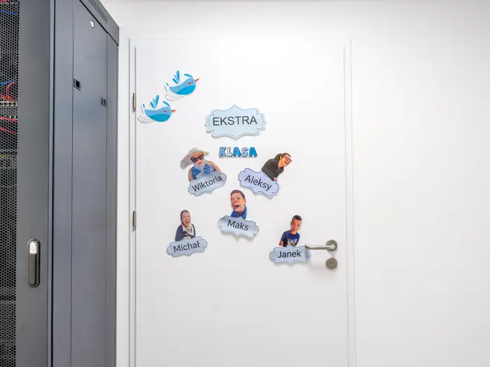 Drzwi klasy Ekstra z tabliczkami z imionami uczniów.