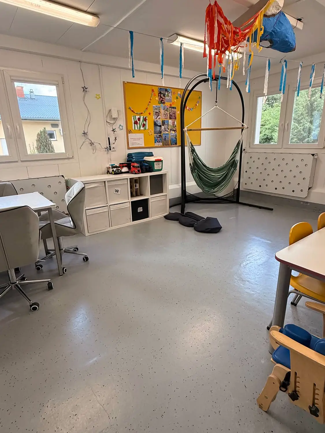 Sala integracji sensorycznej z hamakiem i podwieszanym sprzętem terapeutycznym.
